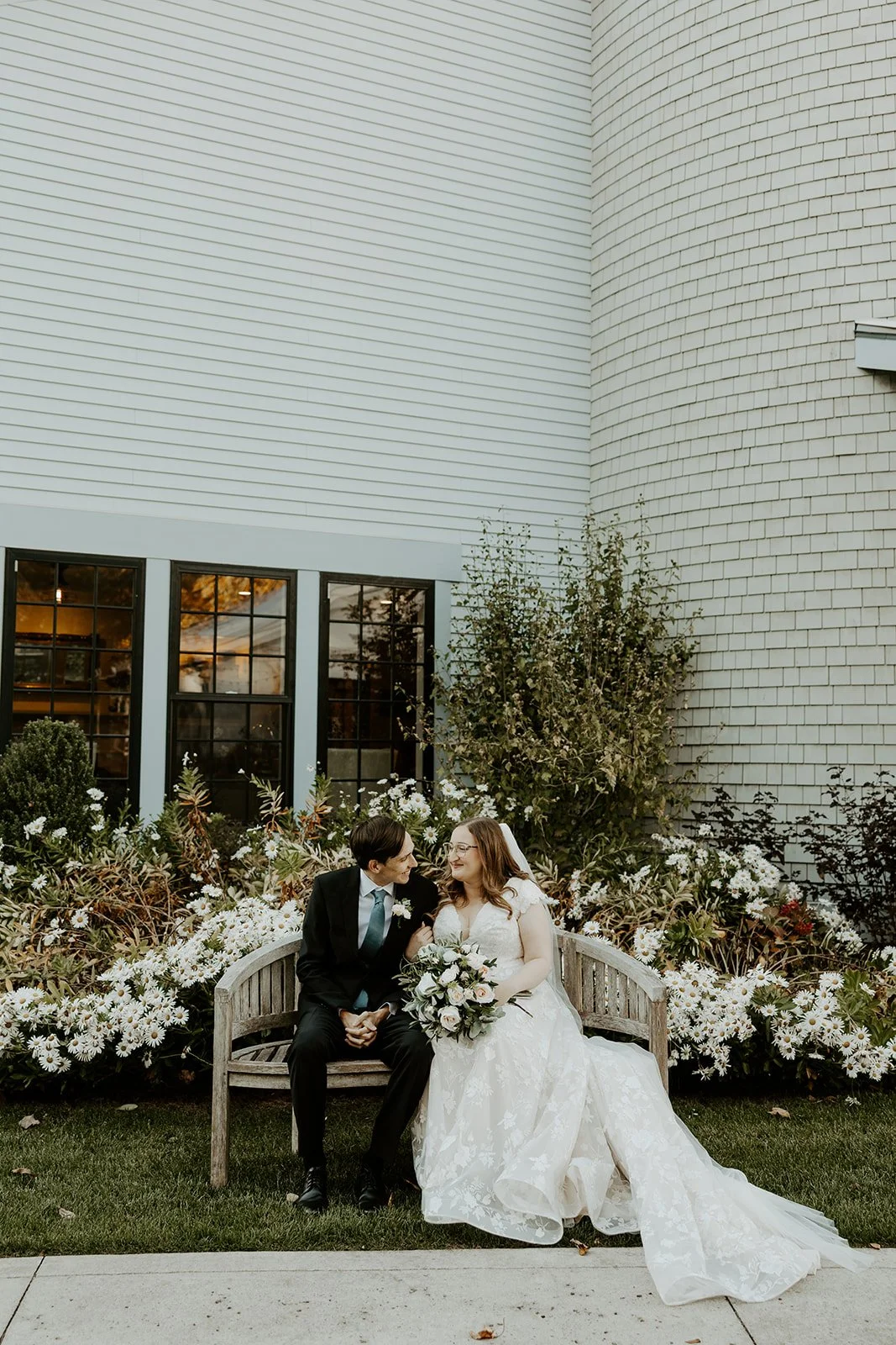 A couple posing for wedding photos in a garden at the grove