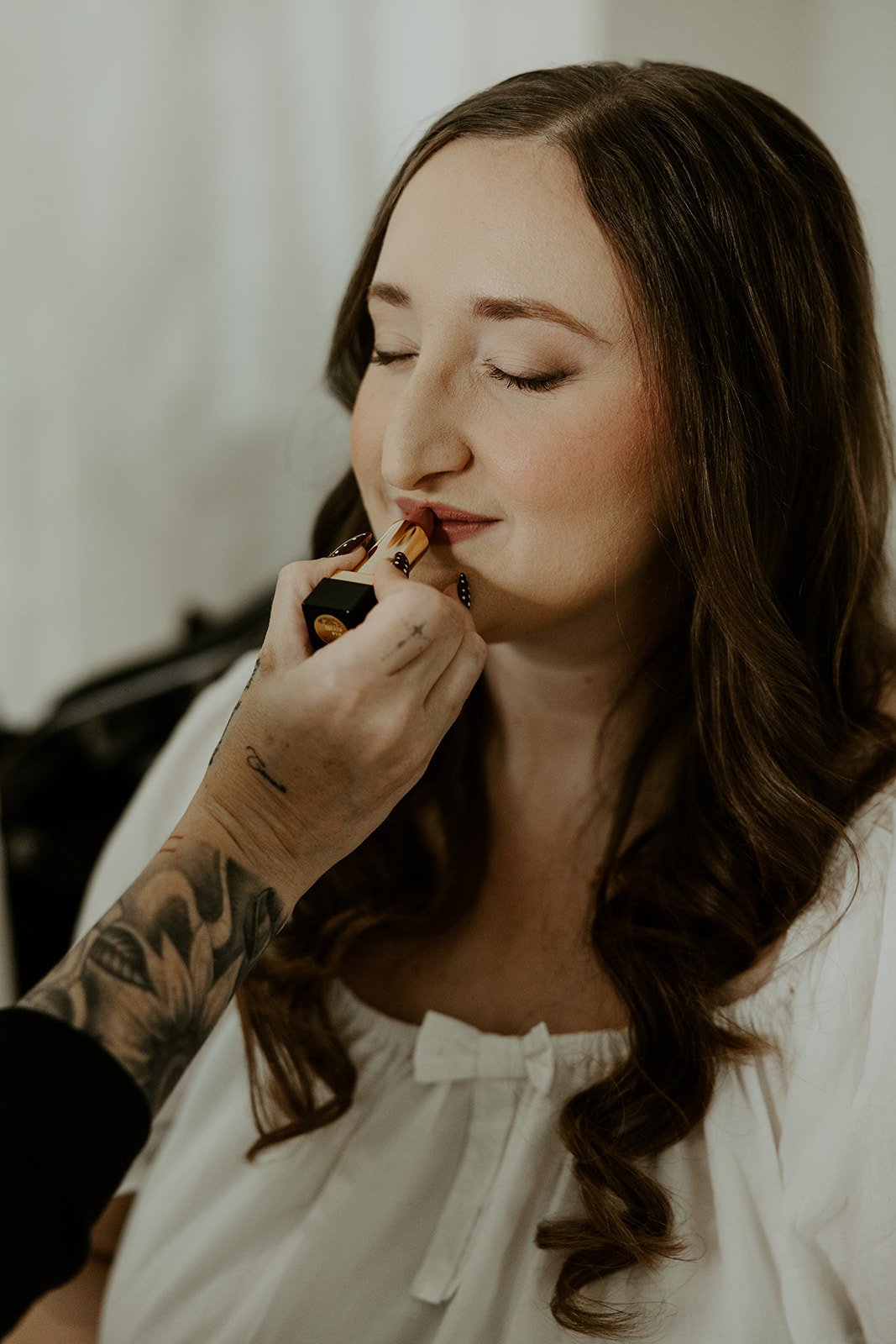 A bride having makeup applied for her wedding
