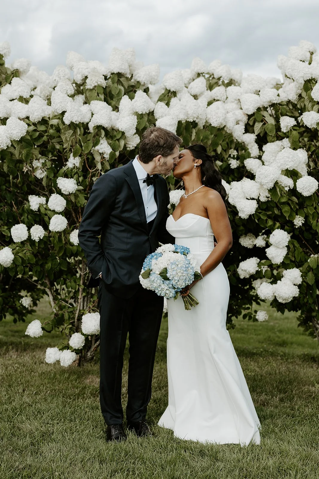 A bride and groom posing for their summer wedding photos
