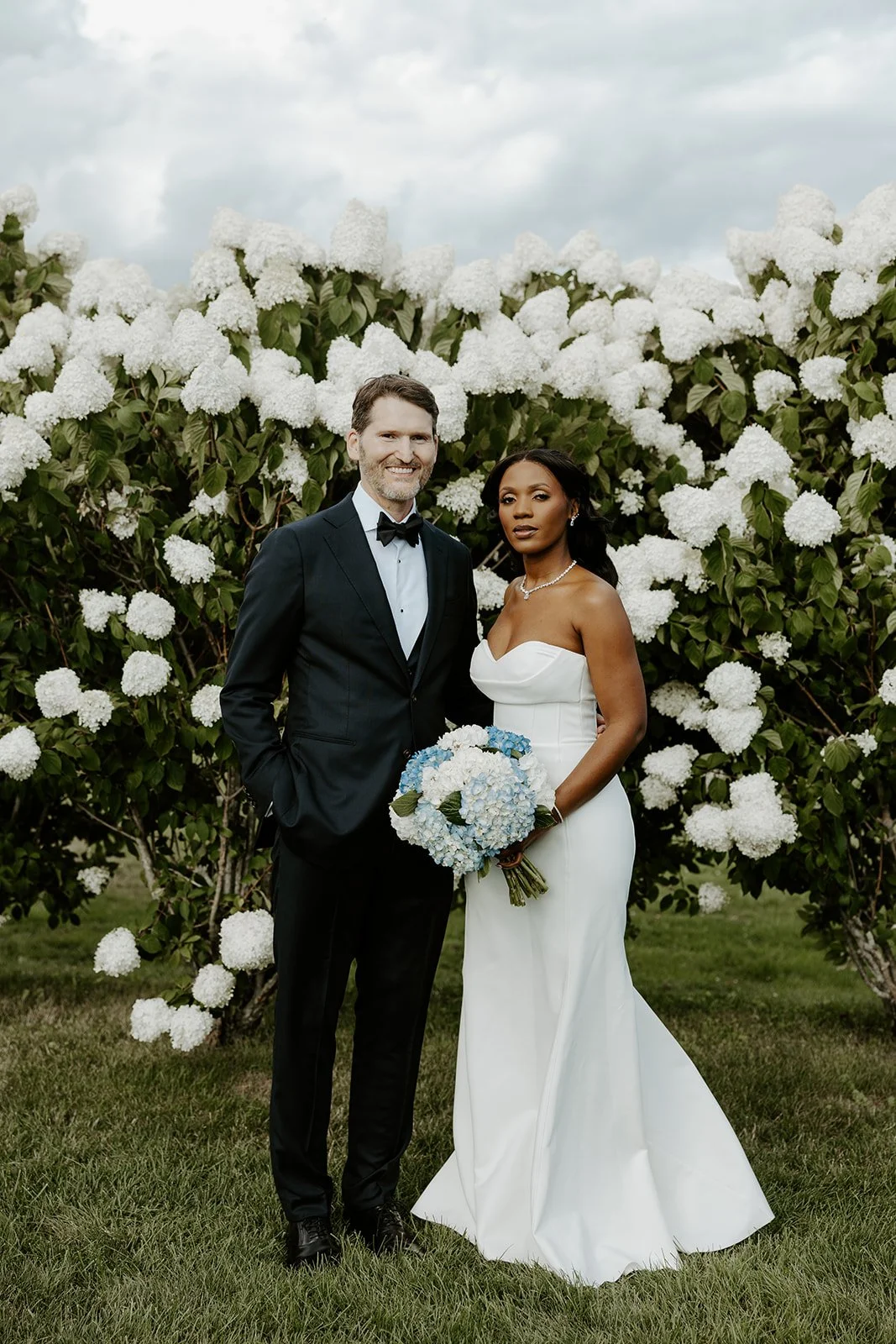 A bride and groom posing for their summer wedding photos