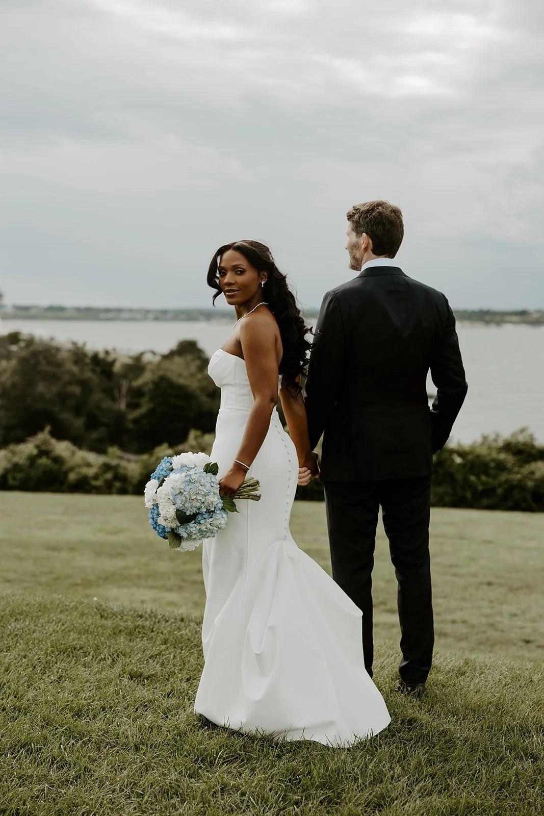 A bride and groom posing for coastal wedding photos