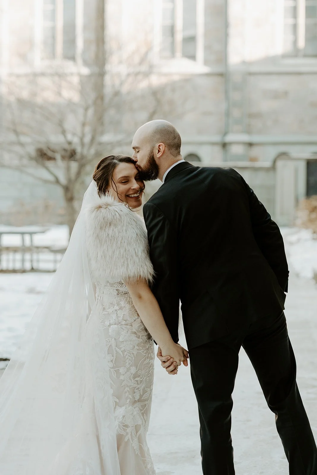 A bride and groom posing for winter wedding photos
