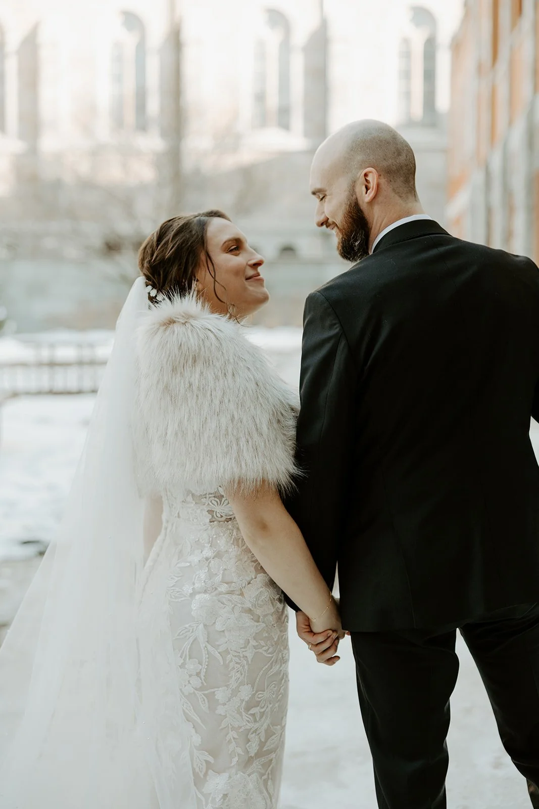 A bride and groom posing for winter wedding photos