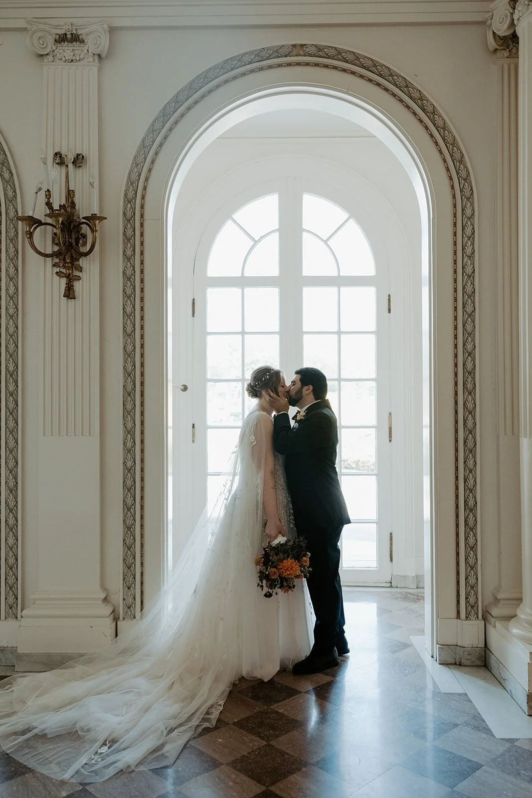 A bride and groom posing for wedding photos in their estate wedding venue