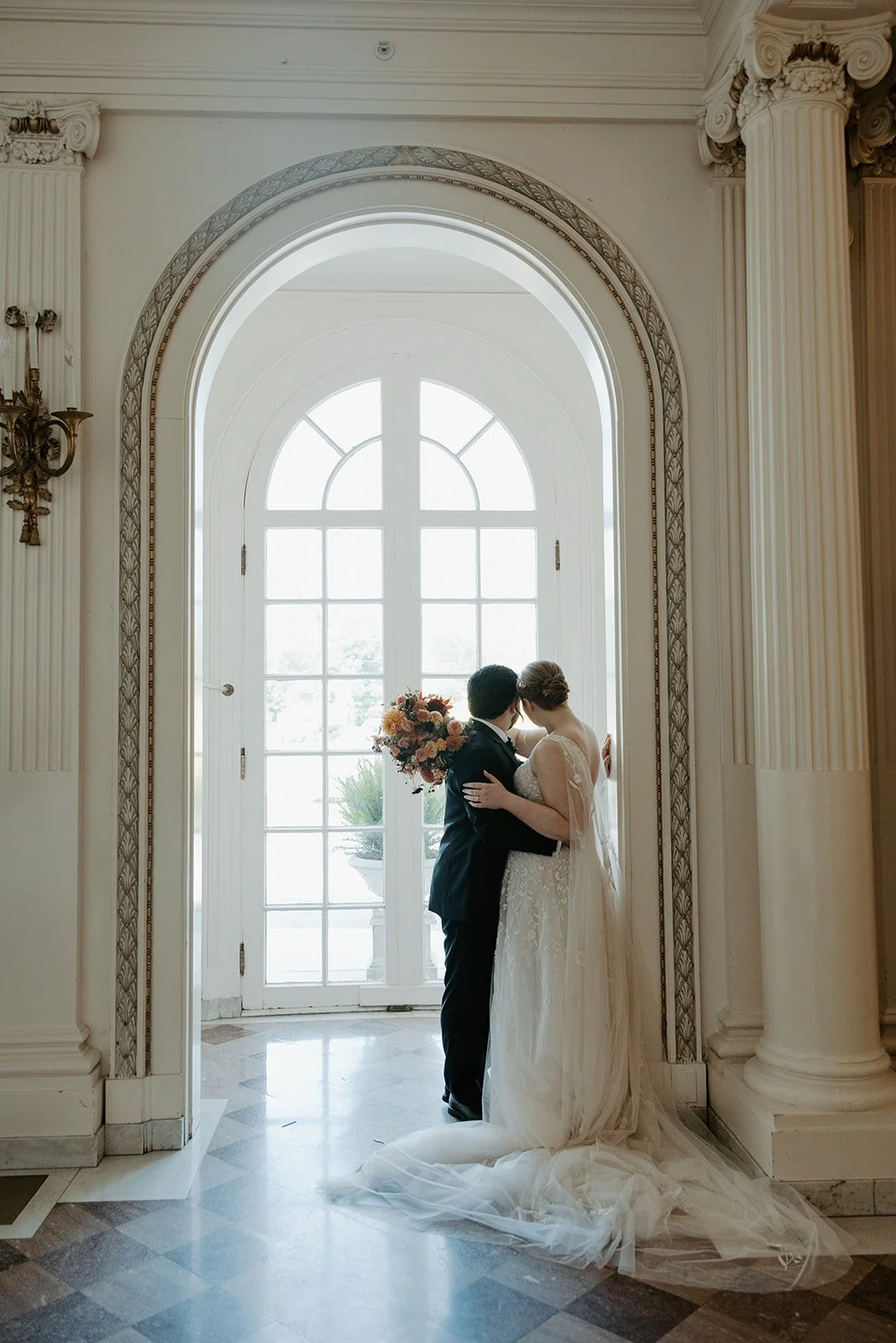 A bride and groom posing for wedding photos in their estate wedding venue