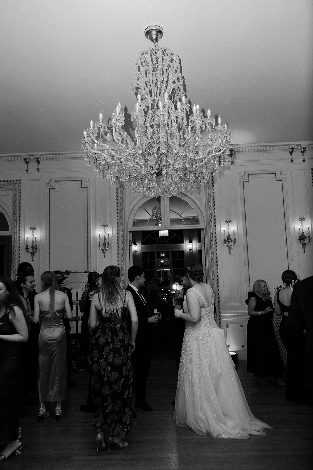 A black and white photo of a wedding reception in an estate wedding venue