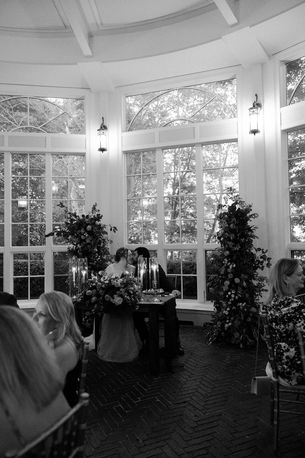 A black and white photo of a wedding reception in an estate wedding venue
