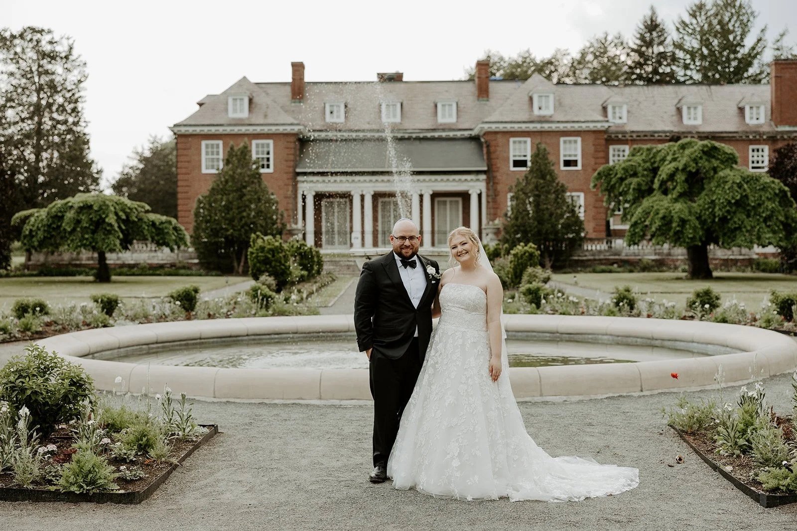 A bride and groom outside of their estate wedding venue