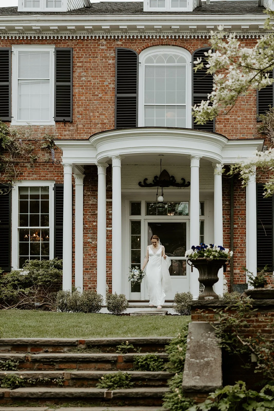 A bride walking out of her estate wedding venue for a first look
