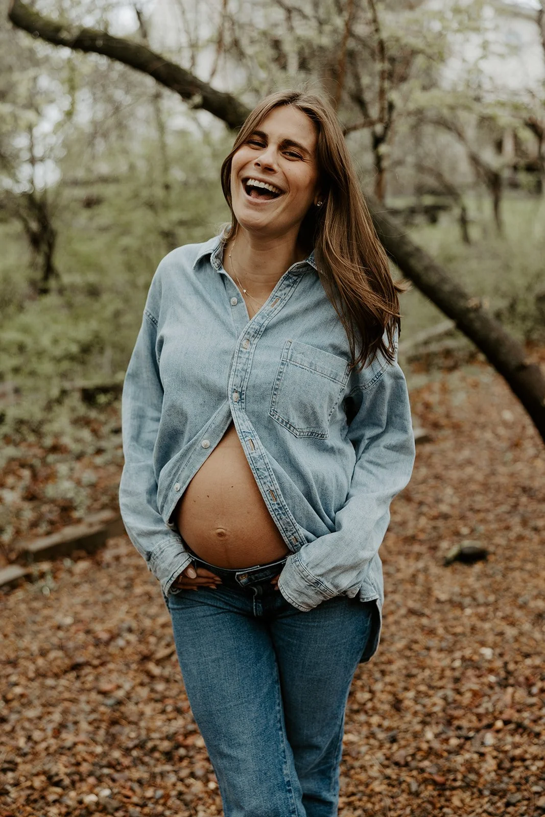 A woman laughing during her maternity photoshoot