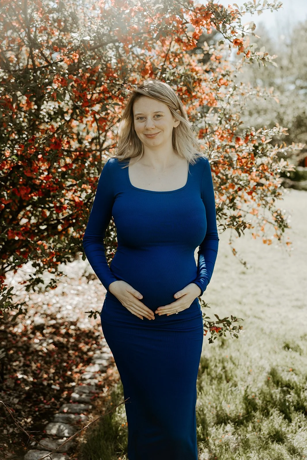 A woman holding her baby bump for maternity photos