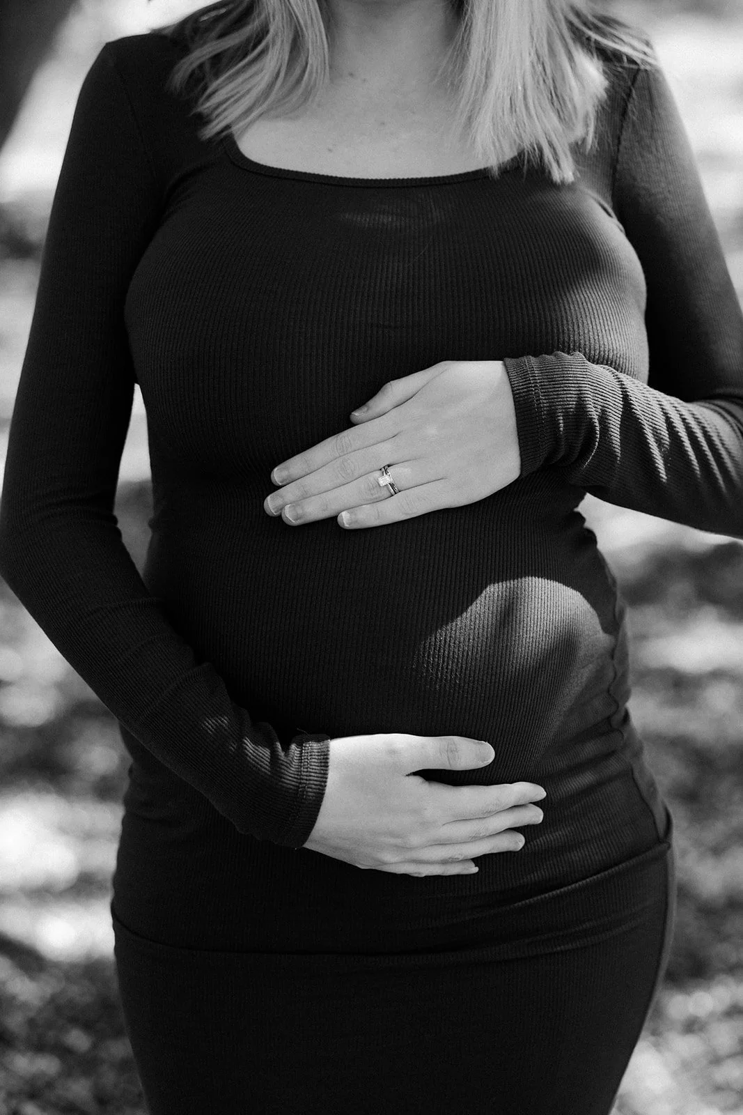 A woman holding her baby bump in maternity photos