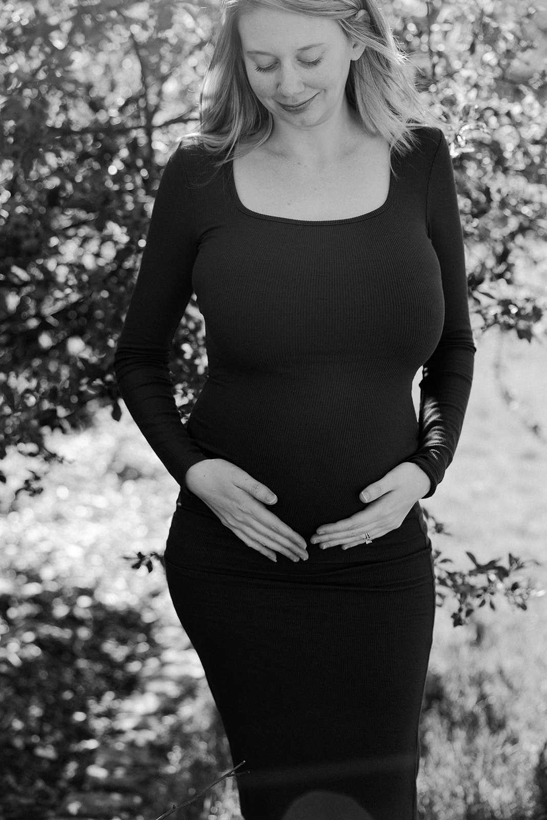 A woman holding her baby bump in maternity photos