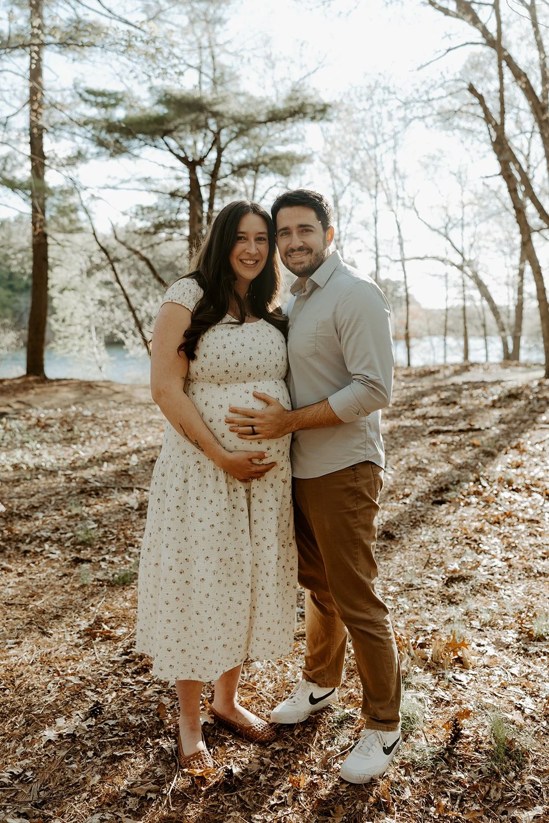 A couple smiling for maternity photos