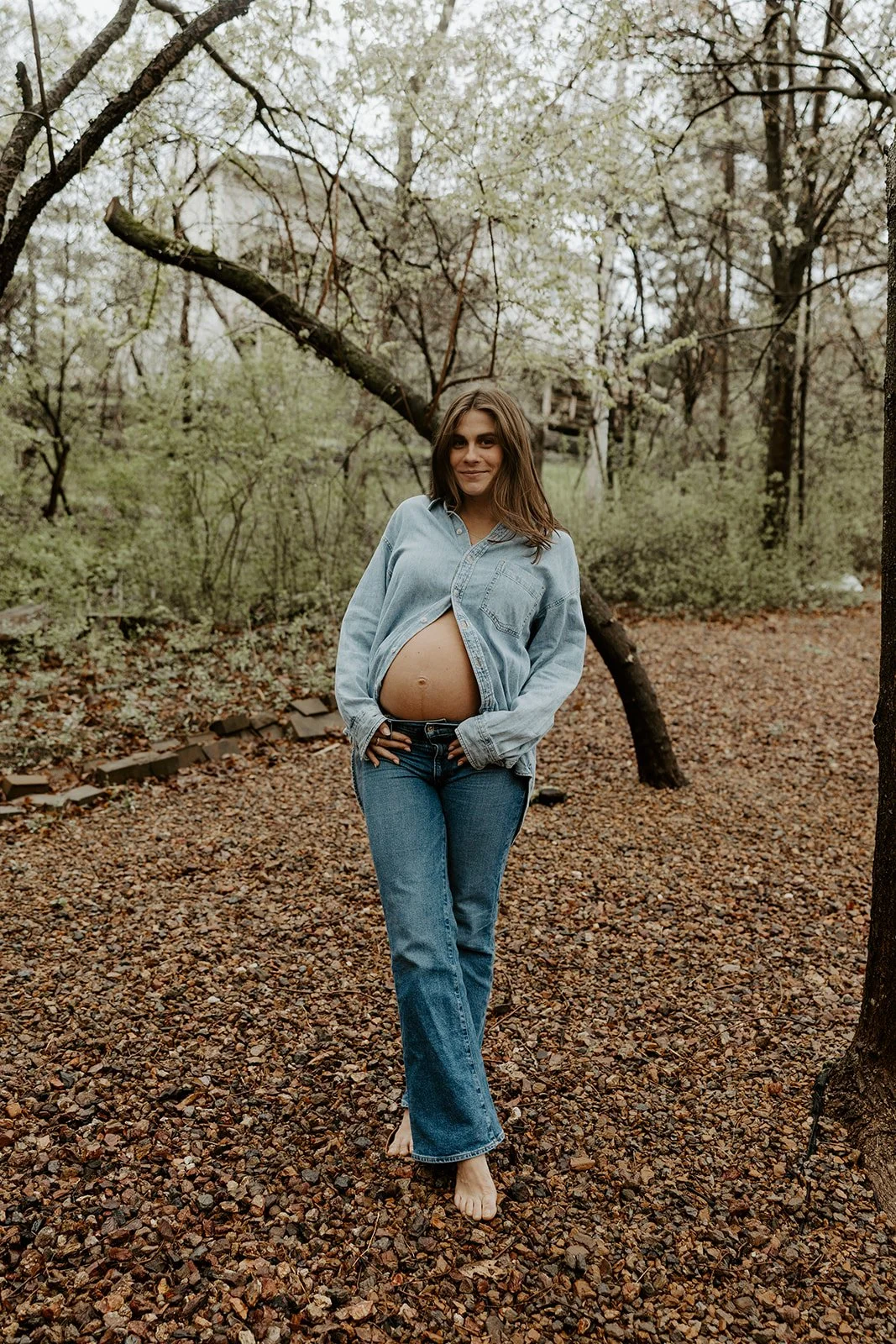 A woman wearing a denim maternity photo outfit