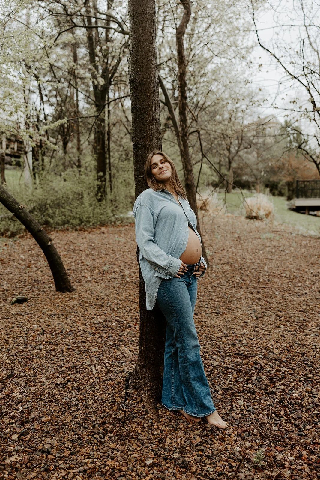 A woman wearing a denim maternity photo outfit