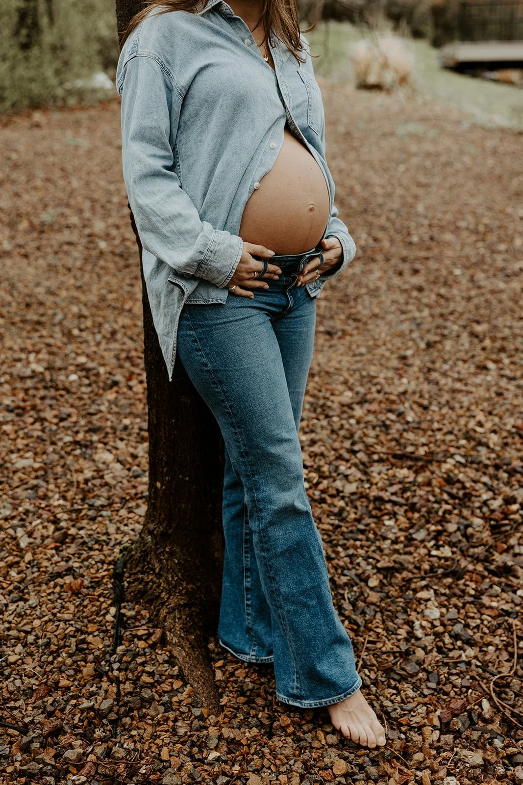 A woman wearing a denim maternity photo outfit