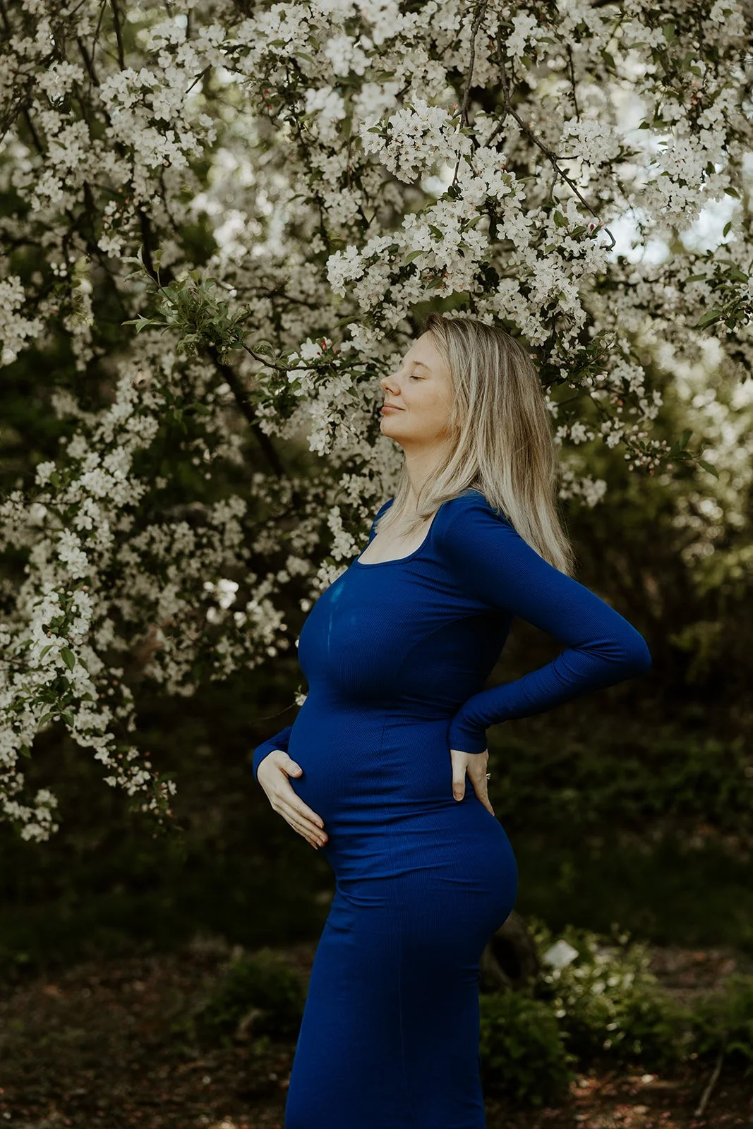 A woman taking spring maternity photos