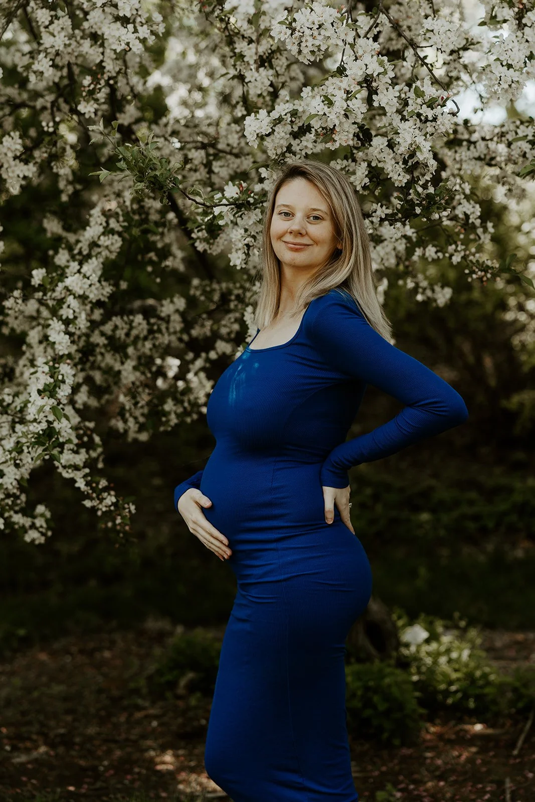 A woman taking spring maternity photos