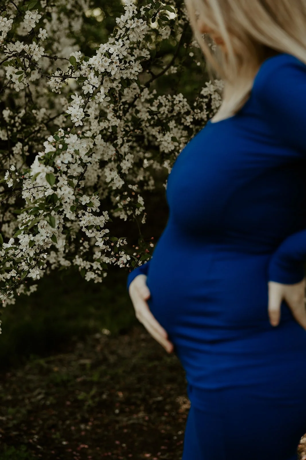 A woman taking spring maternity photos