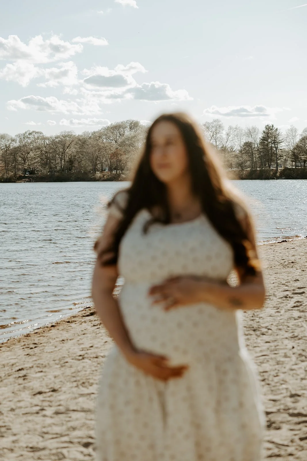 A woman in a maternity photoshoot on the beach