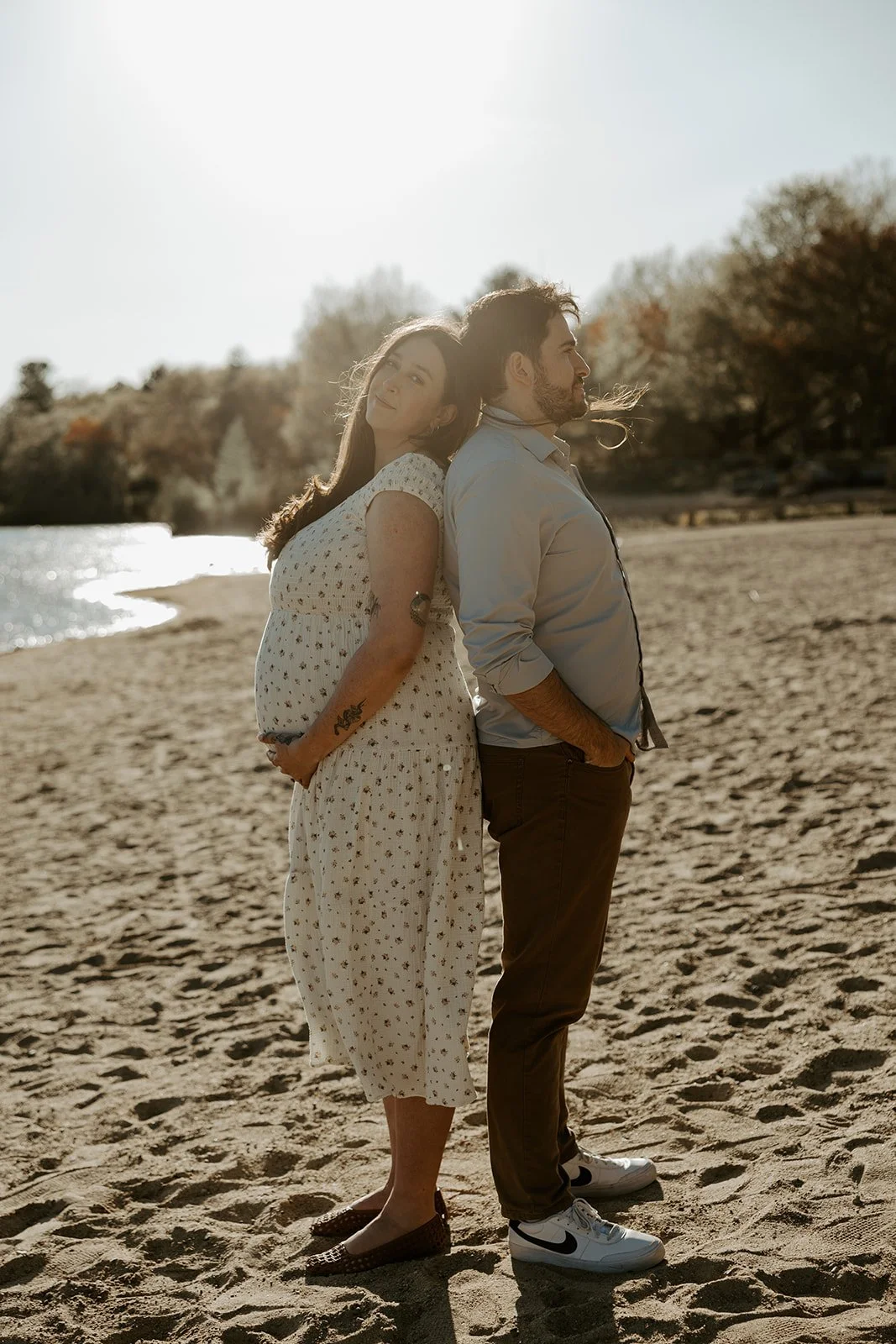 A couple taking beach maternity photos
