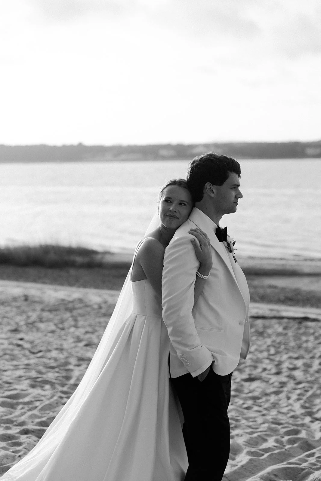 A bride and groom on the beach at their coastal wedding