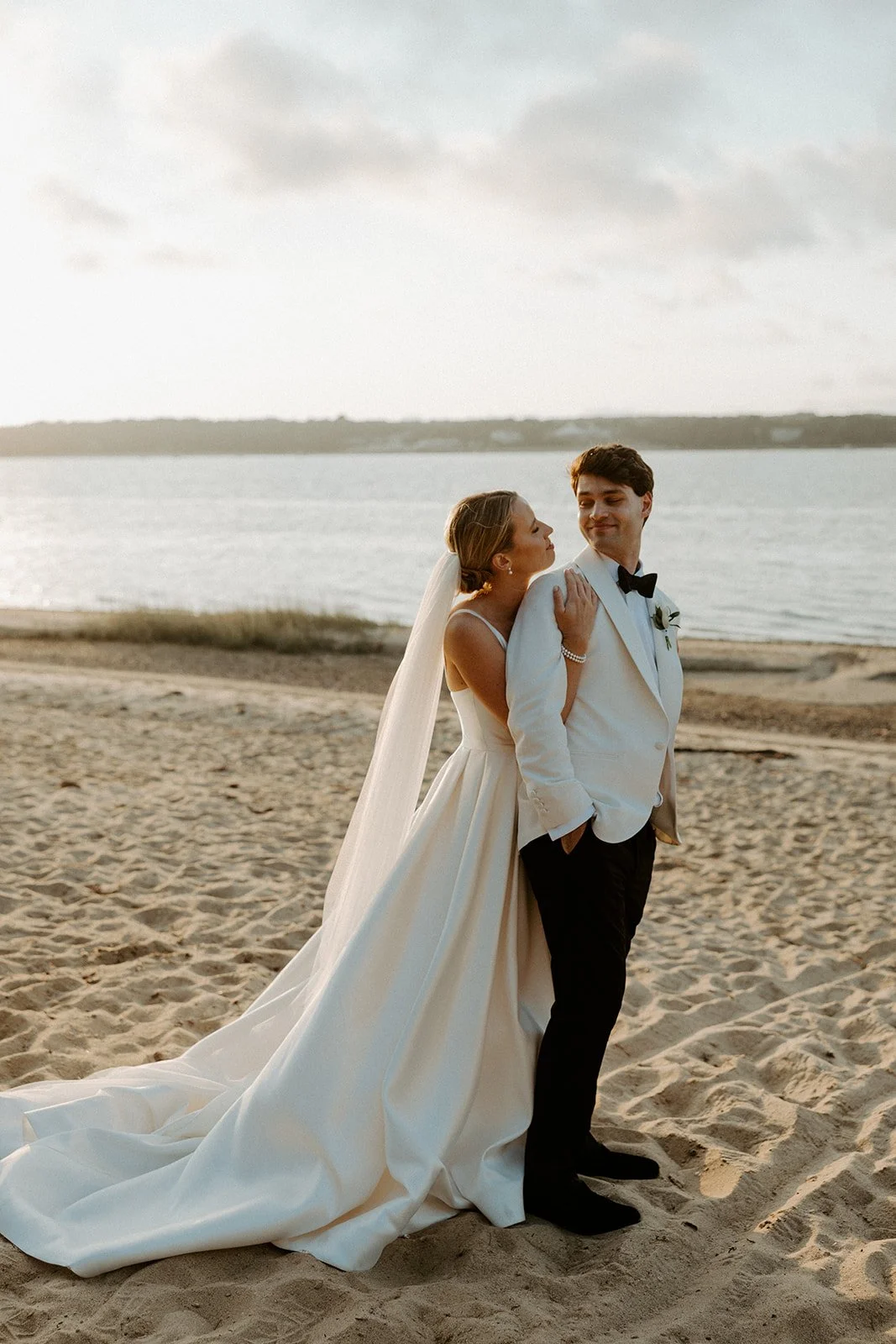 A bride and groom on the beach at their coastal wedding