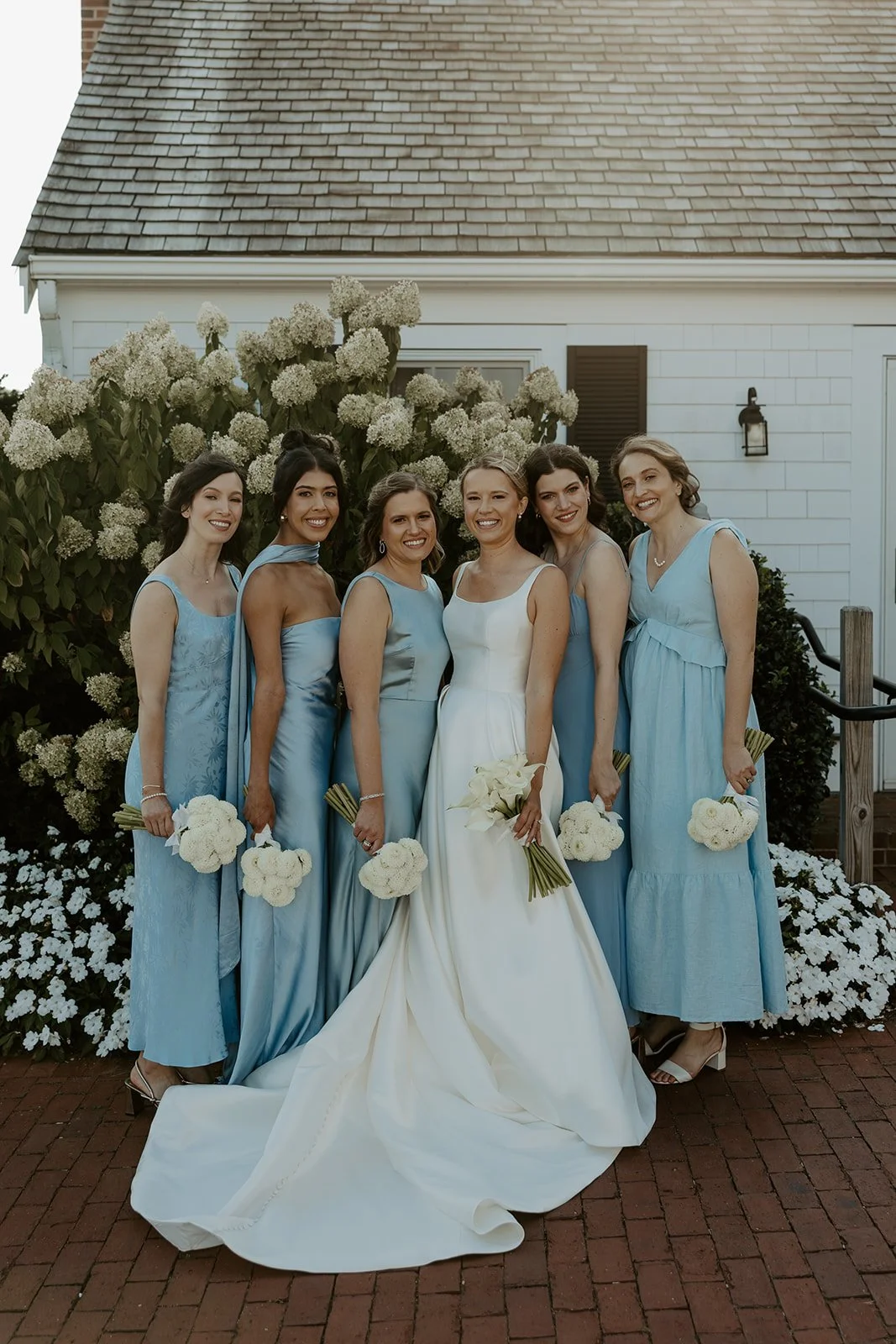 Bridesmaids wearing blue bridesmaid dresses at a coastal wedding