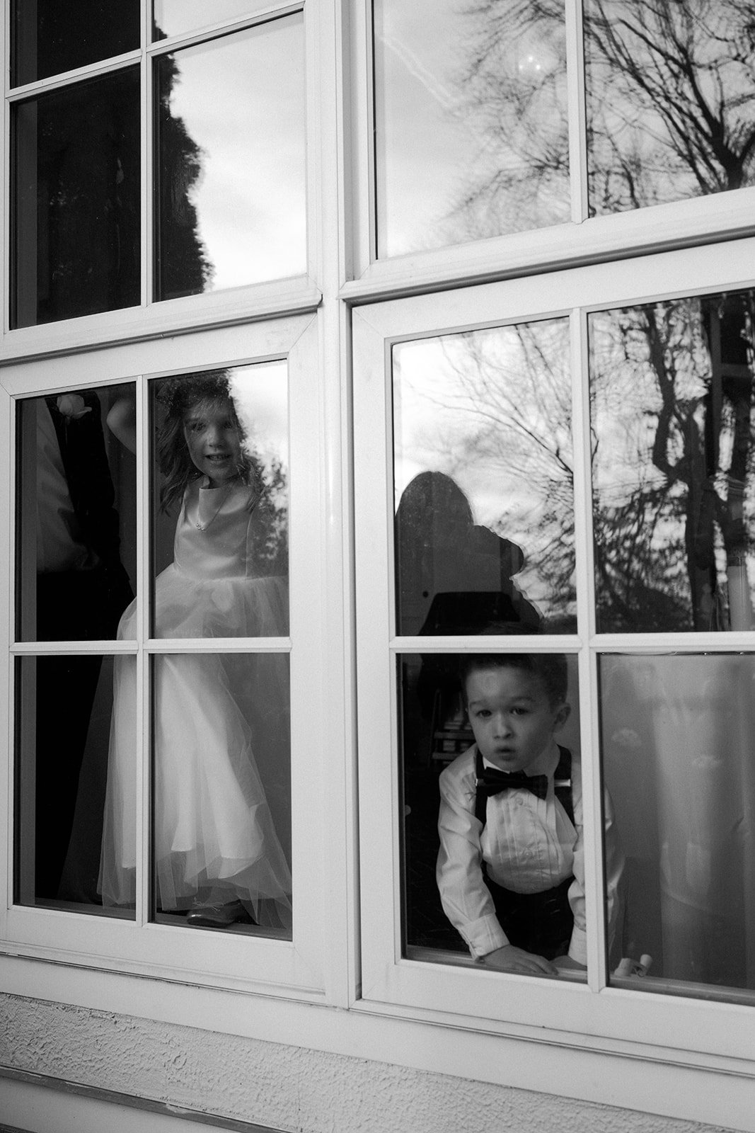 A flower girl and ring bearer looking at a bride in an estate wedding