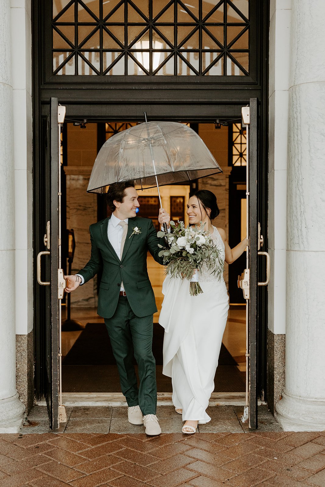 A bride and groom on a rainy wedding day