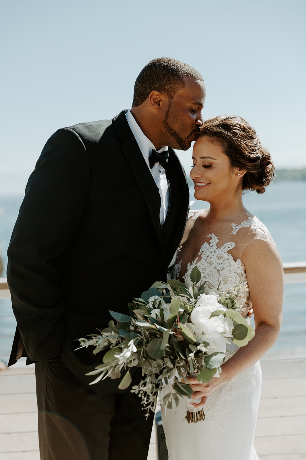 A bride and groom posing for photos at their Beauport Hotel wedding