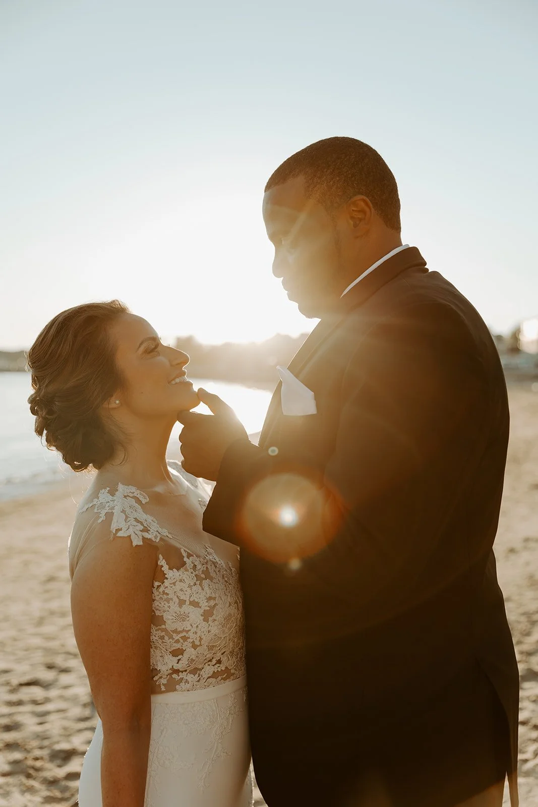 A bride and groom taking beach sunset wedding photos