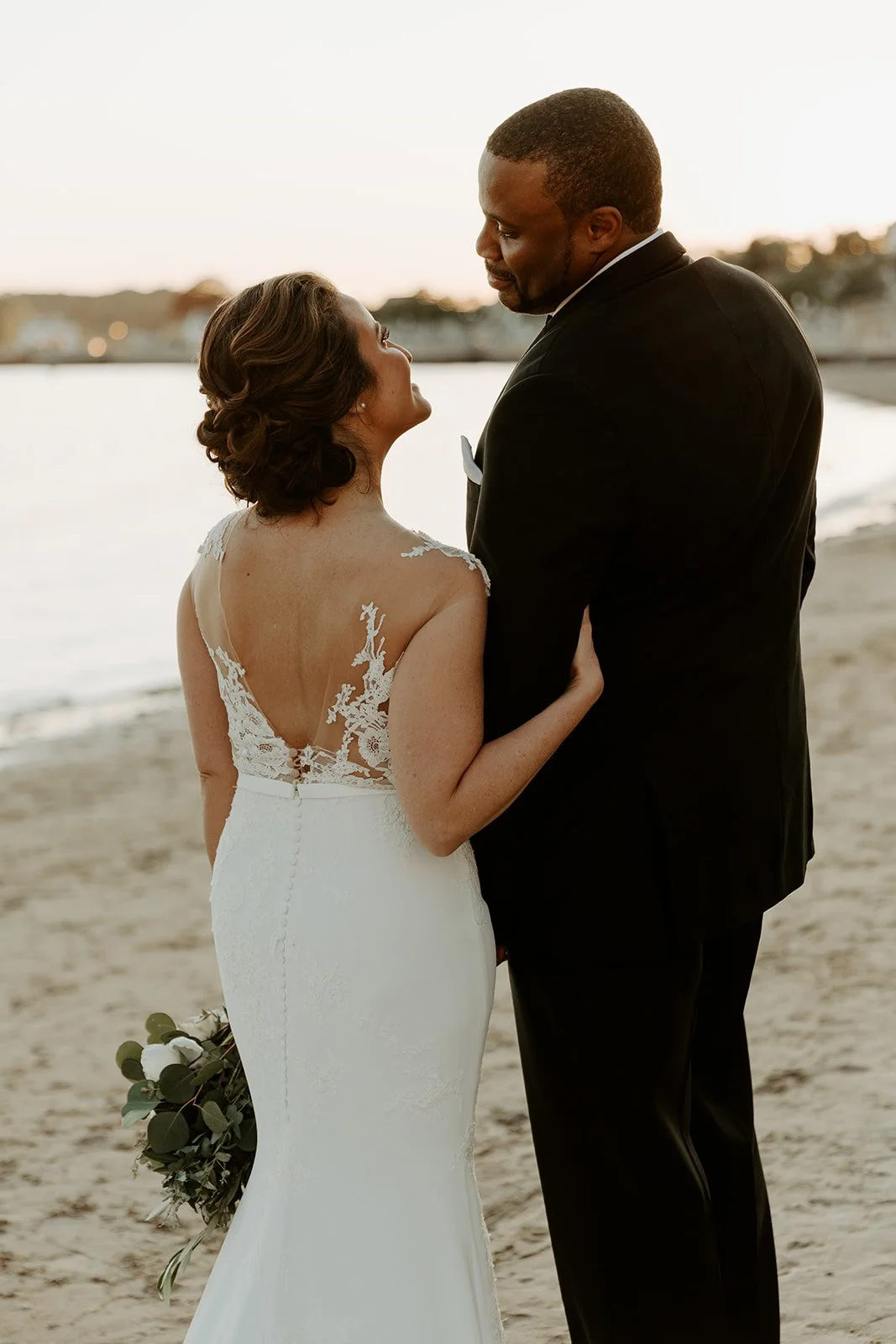 A bride and groom taking beach sunset wedding photos