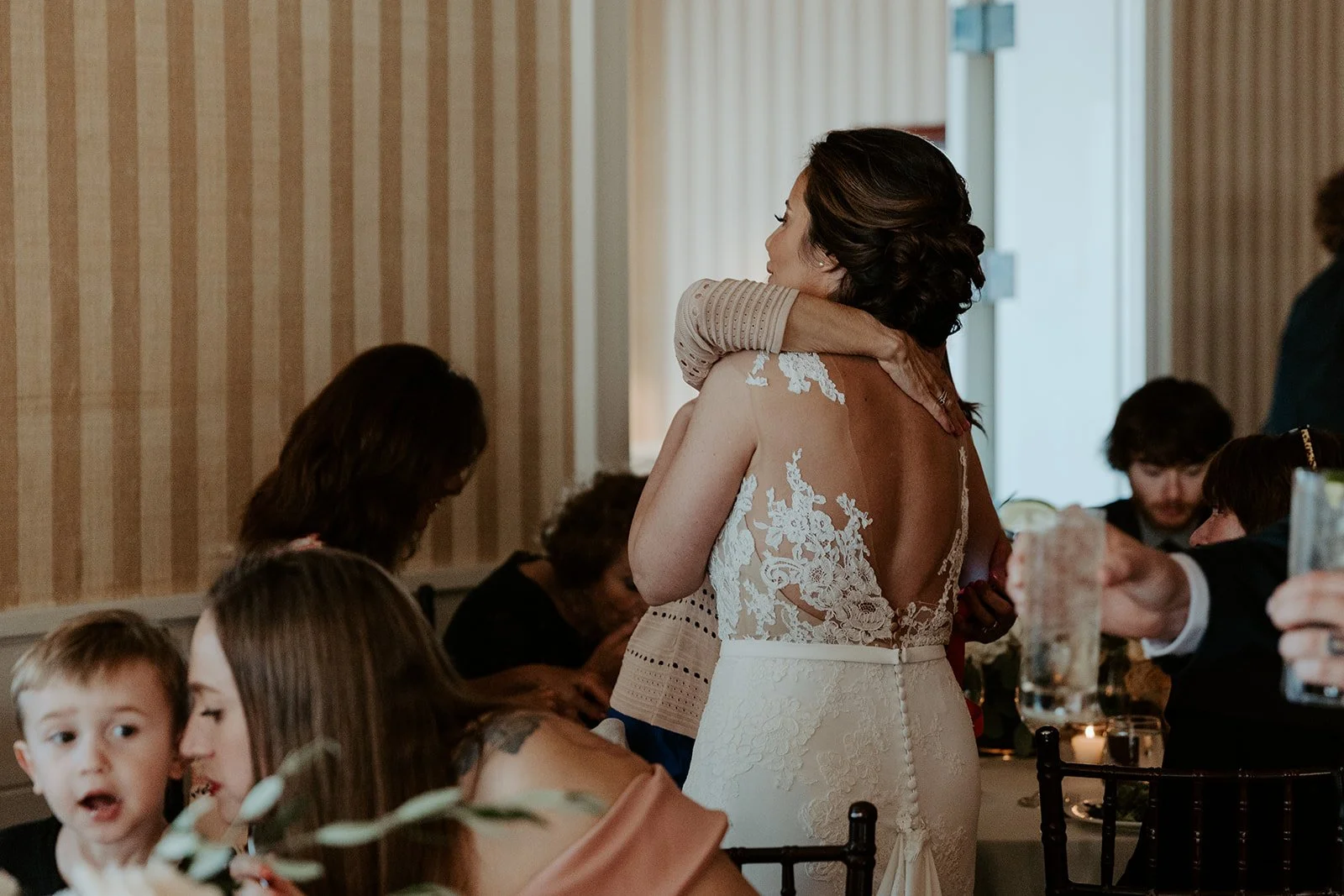 A bride hugging a wedding guest