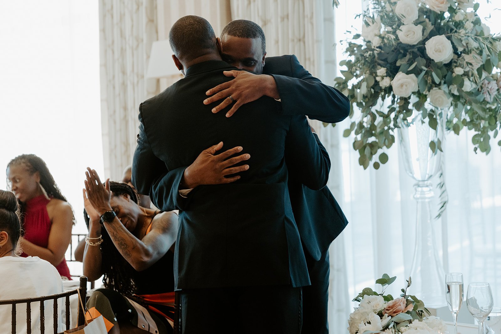 A groom hugging a wedding guest