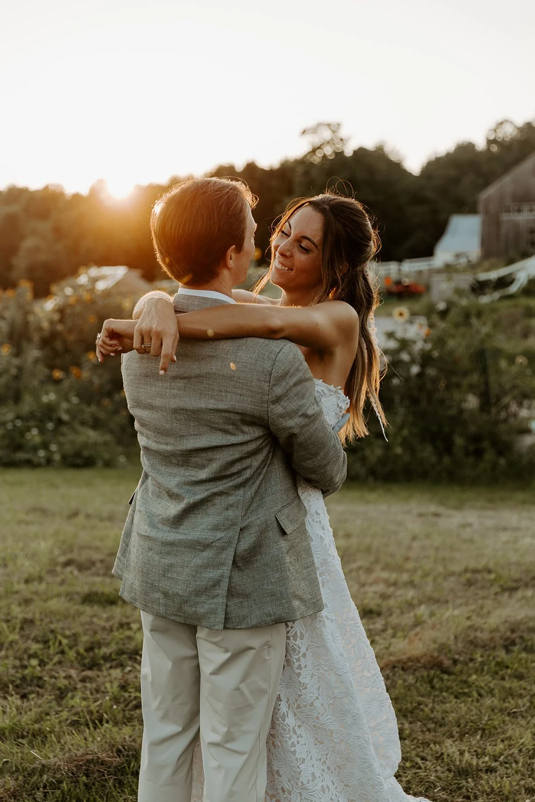 A bride and groom taking sunset photos at their Maine wedding venue