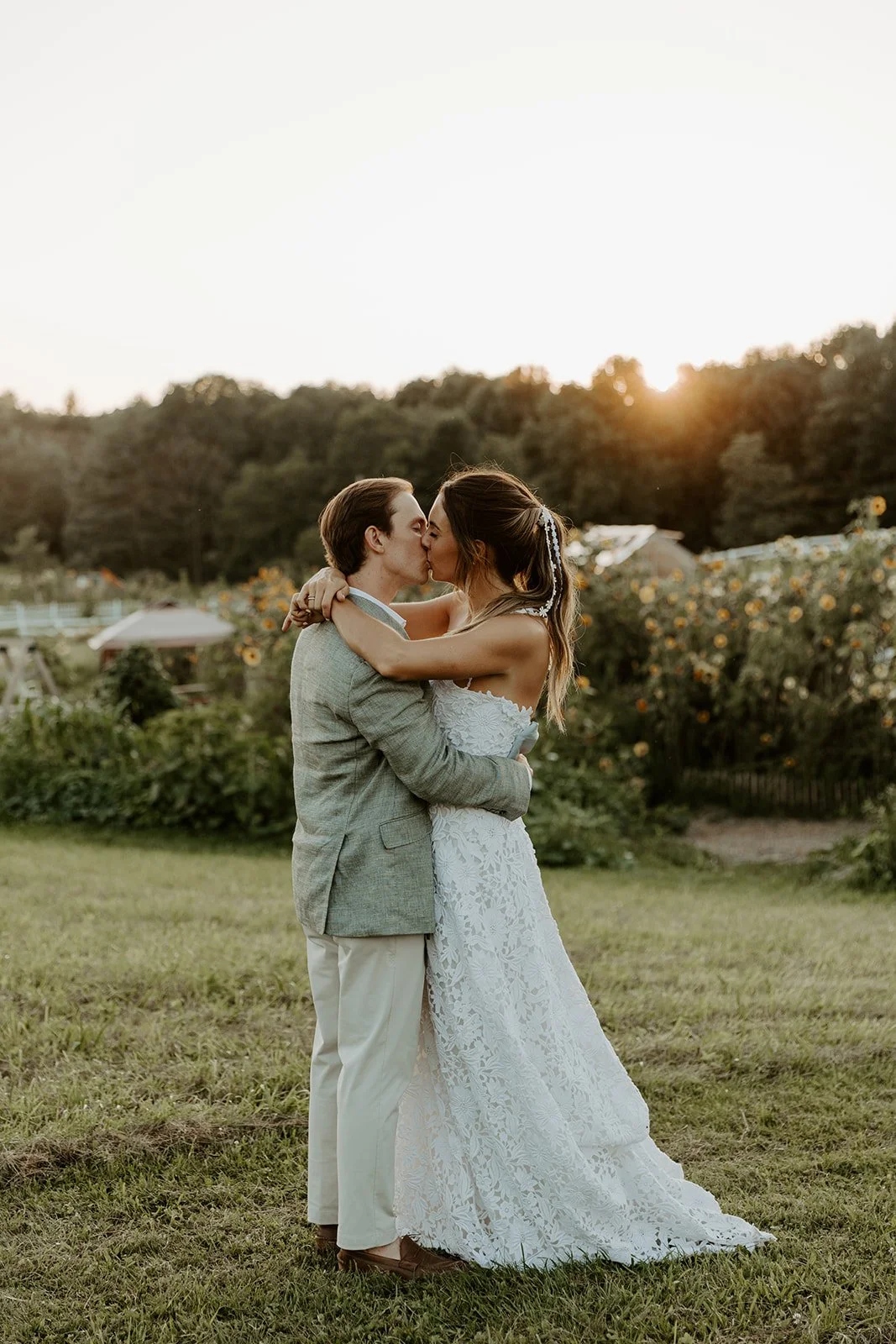 A bride and groom taking sunset photos at their Maine wedding venue