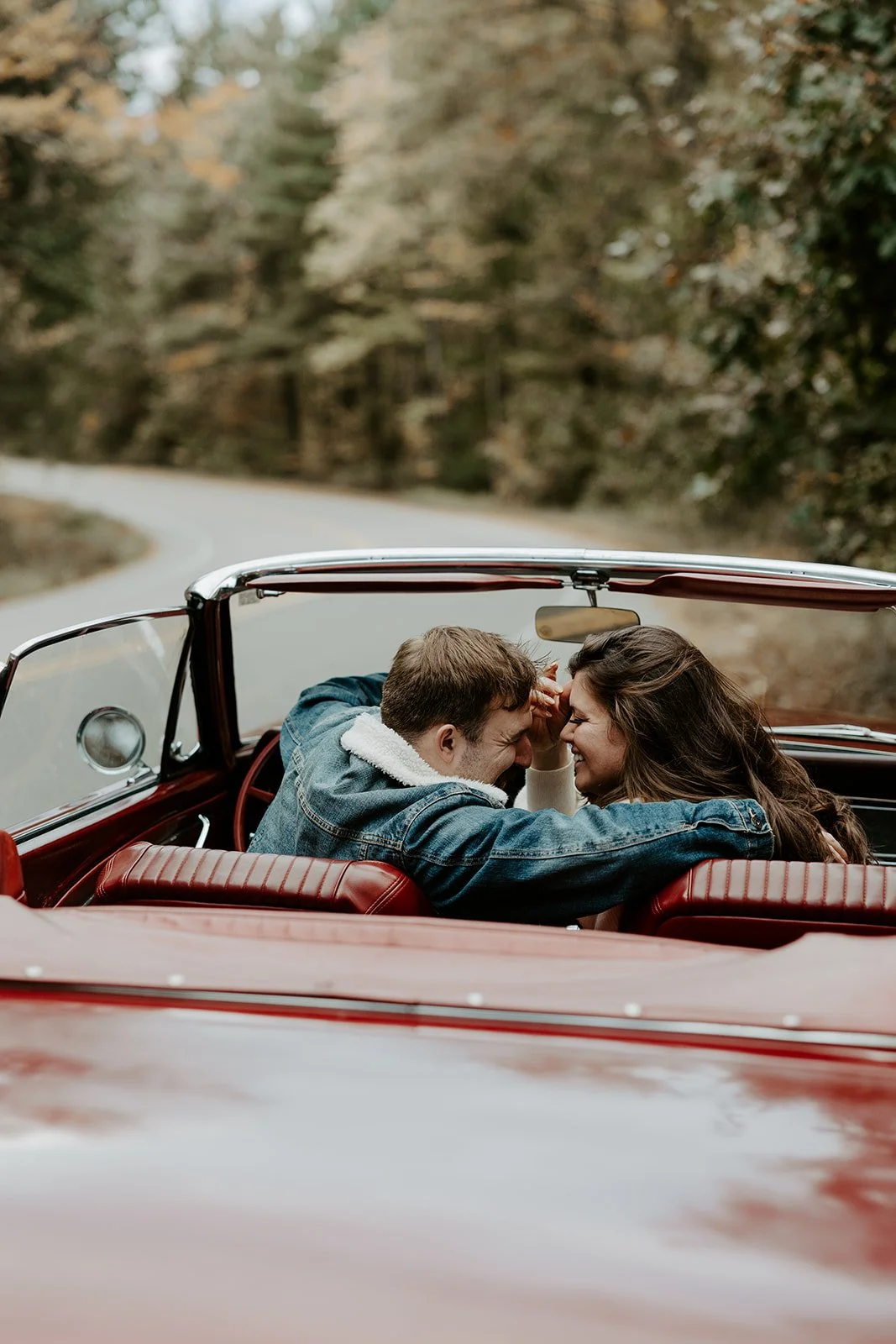 A couple taking vintage car engagement photos