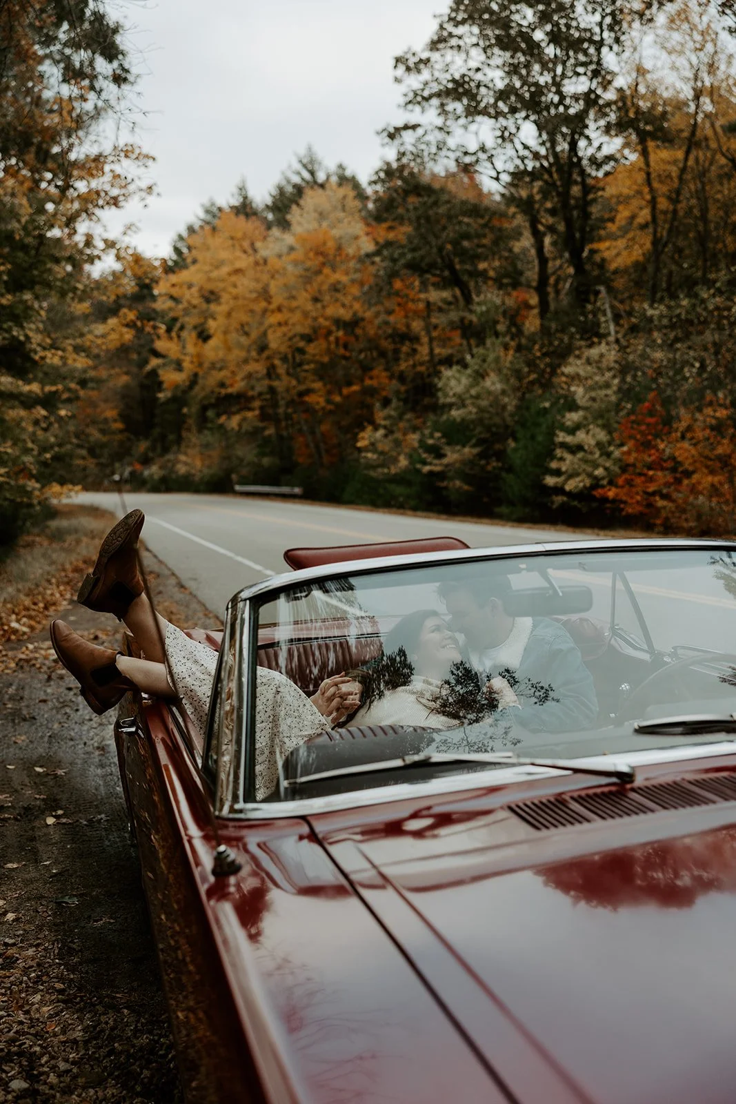 A couple taking vintage car engagement photos