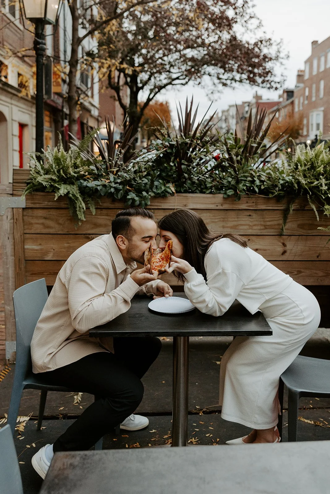 A couple eating pizza during engagement photos