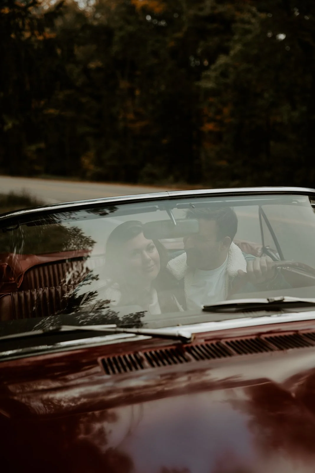 A couple taking vintage car engagement photos