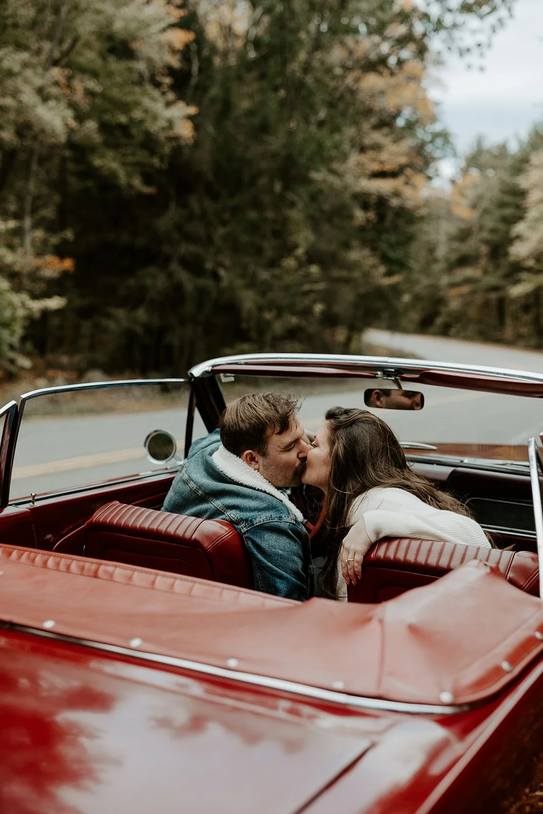 A couple taking vintage car engagement photos