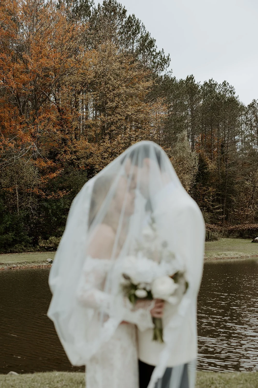 A bride and groom posing for fall wedding photos
