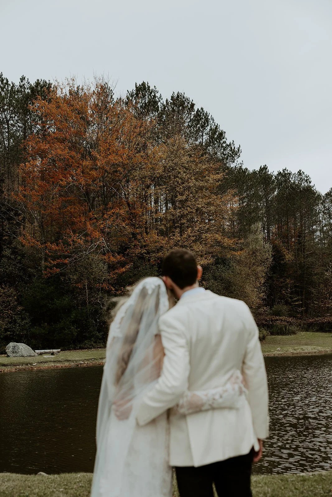 A bride and groom posing for fall wedding photos