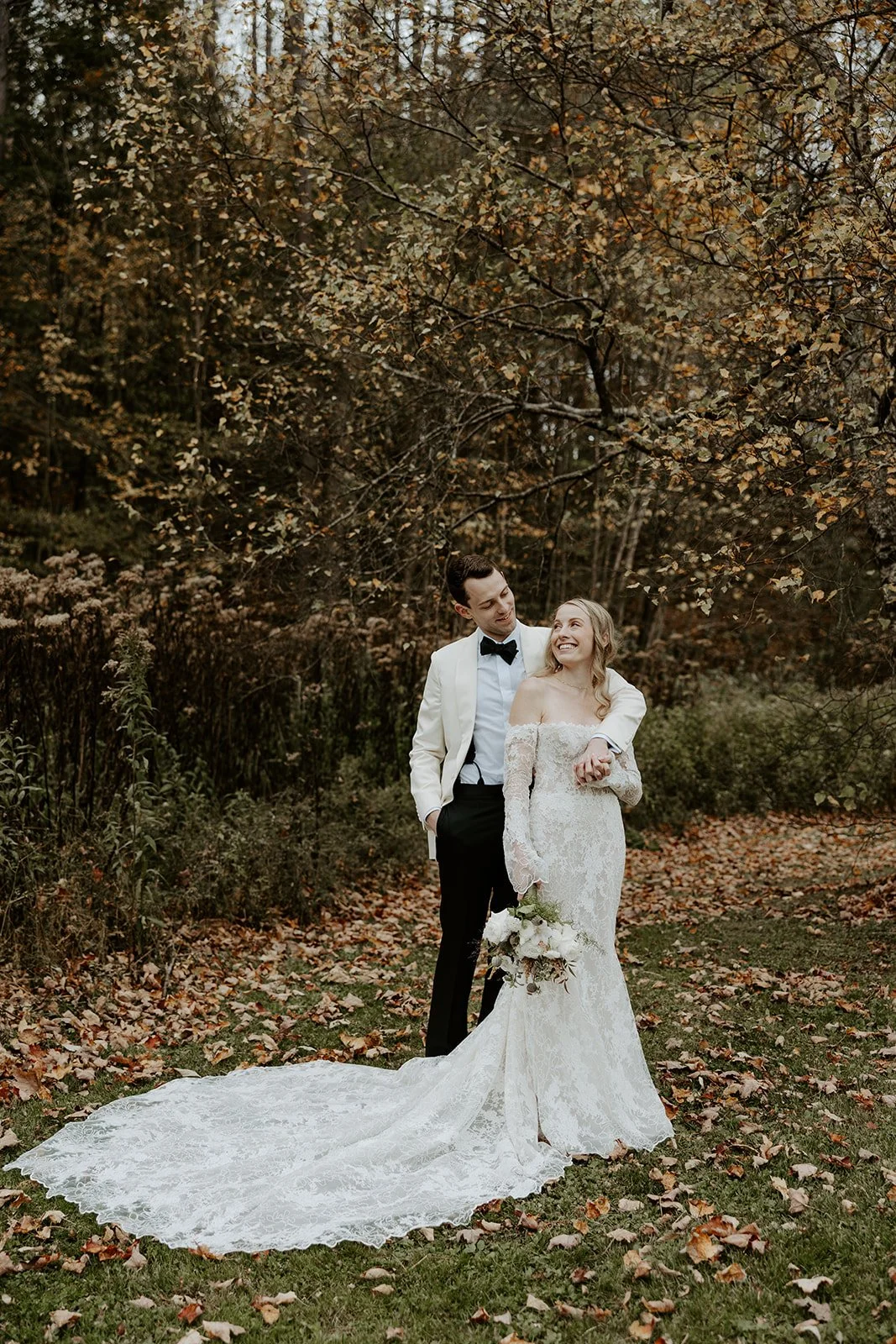 A bride and groom taking fall wedding photos
