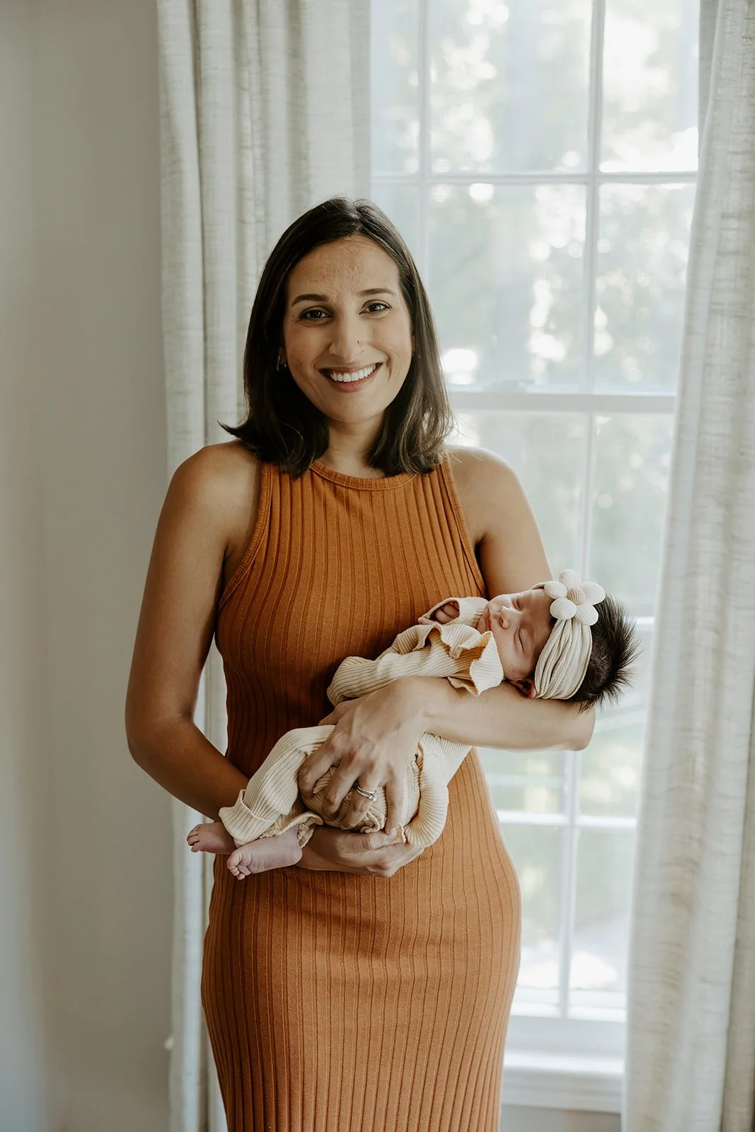 A mom posing for newborn photos with a boston newborn photographer