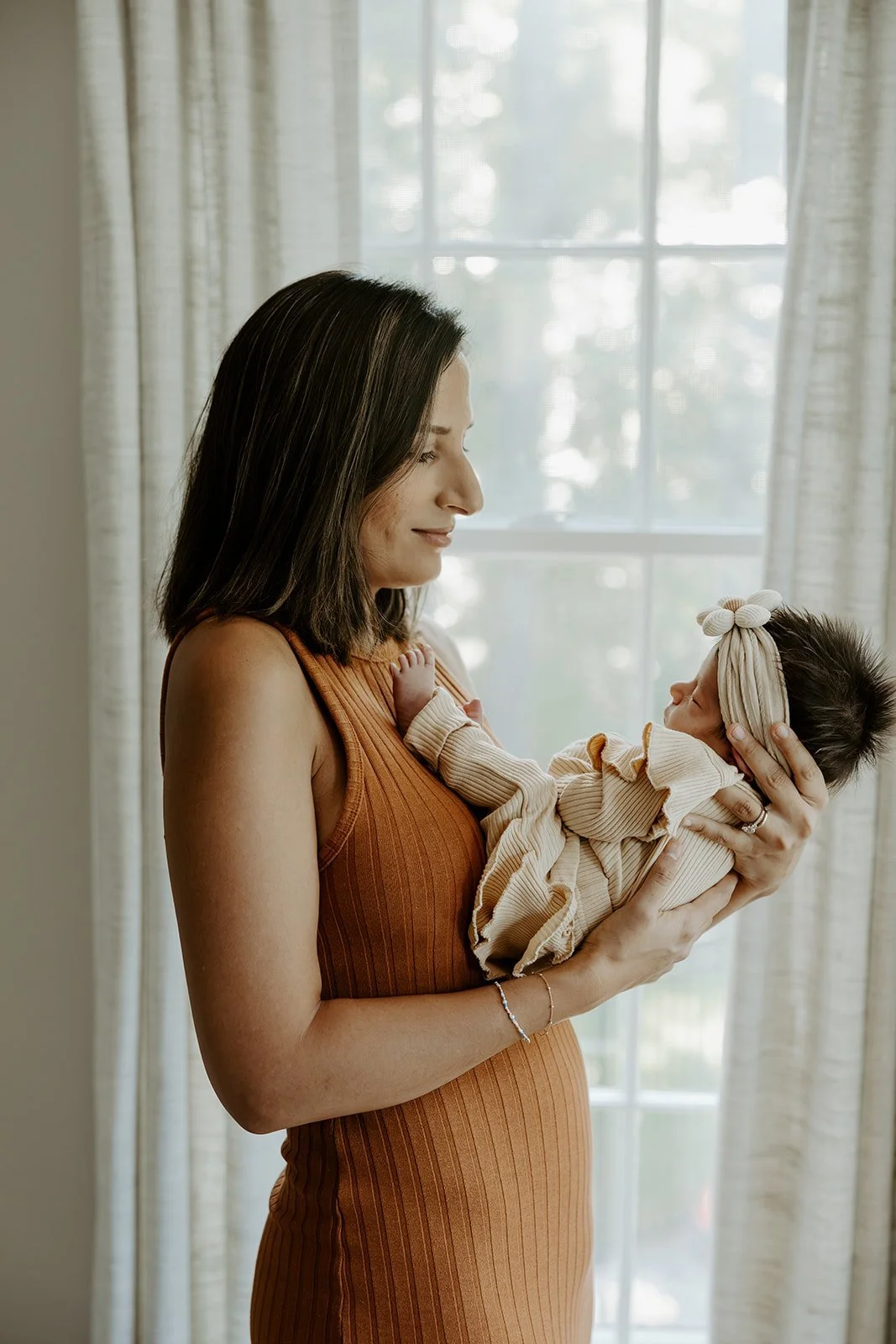 A mom posing for newborn photos with a boston newborn photographer