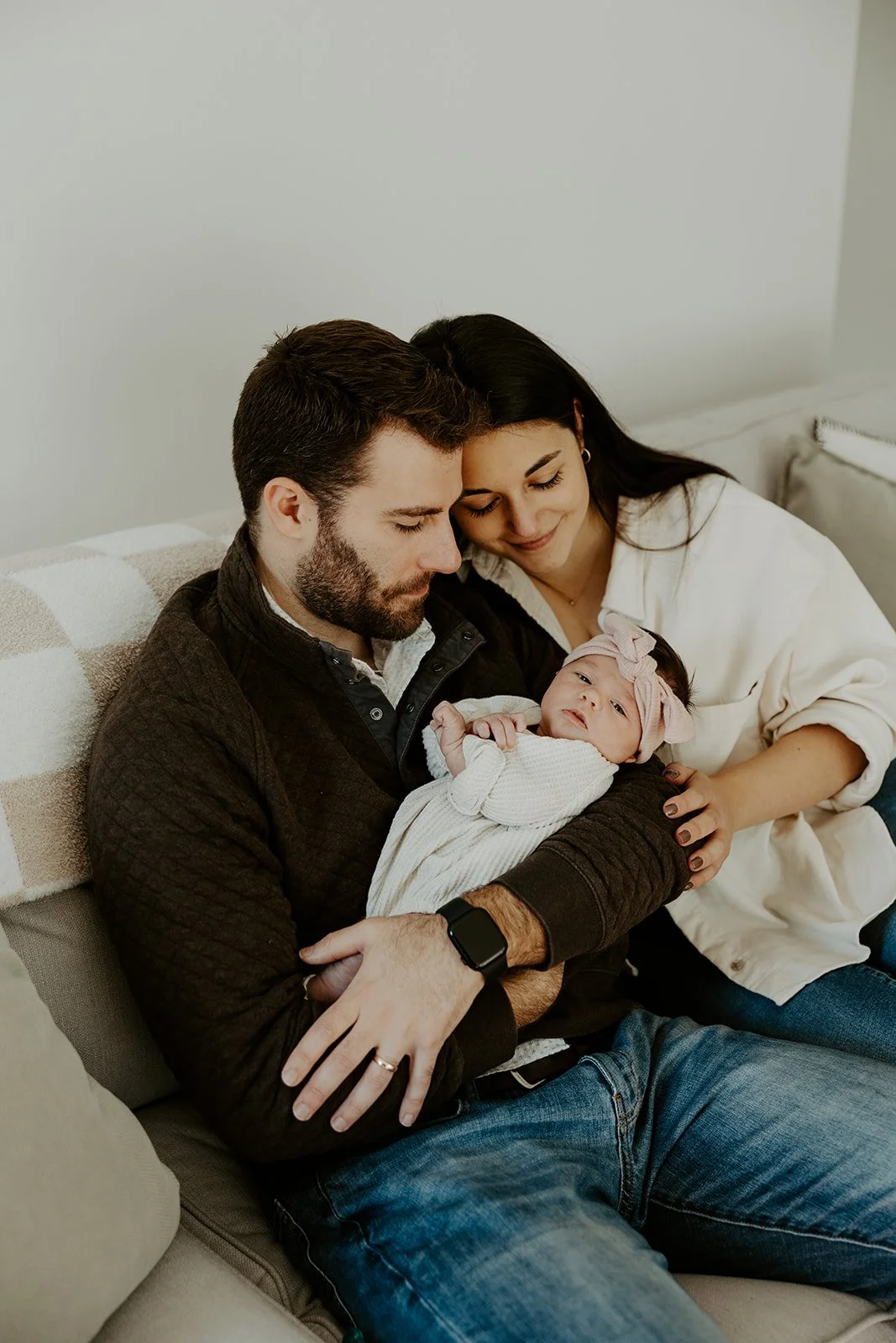 A family on their couch during newborn photos