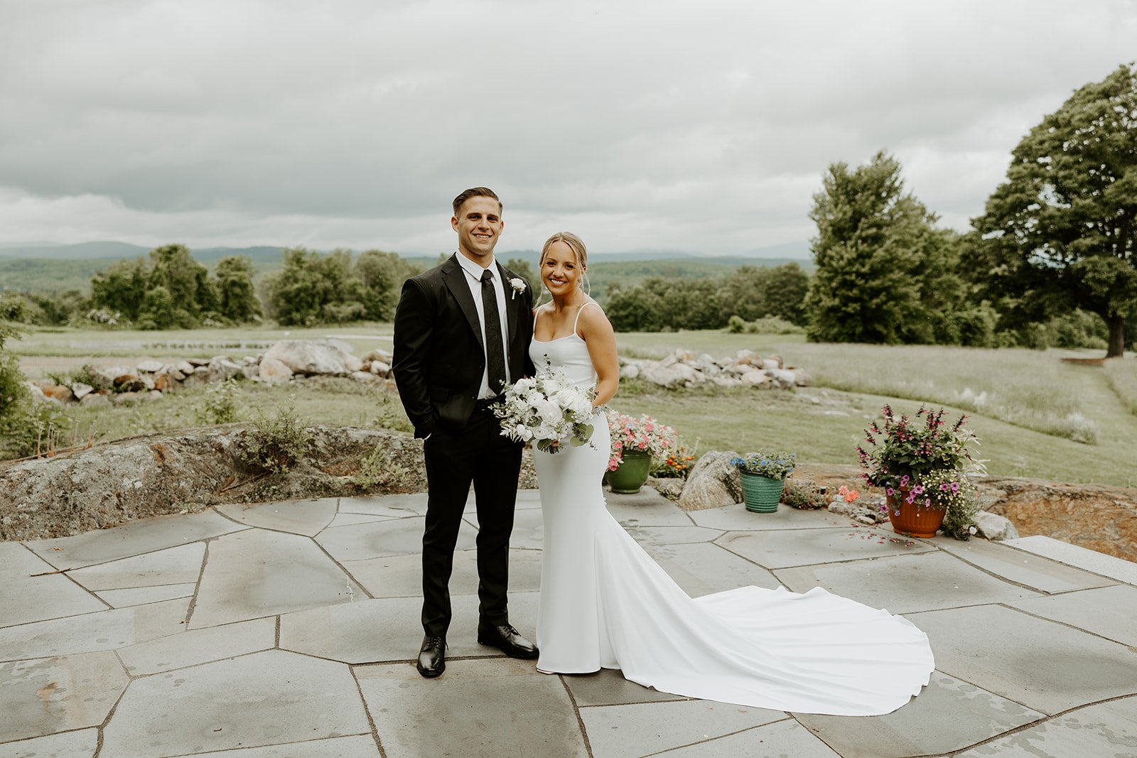 A bride and groom posing for wedding photos in front of mountains